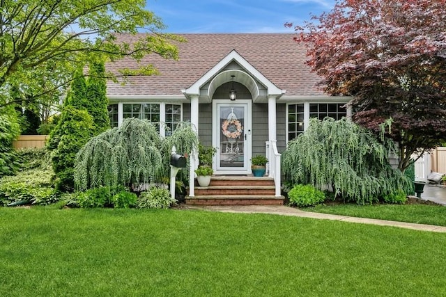 2209 Post St, East Meadow, NY 11554 - view of front of home with a shingled roof and a front lawn