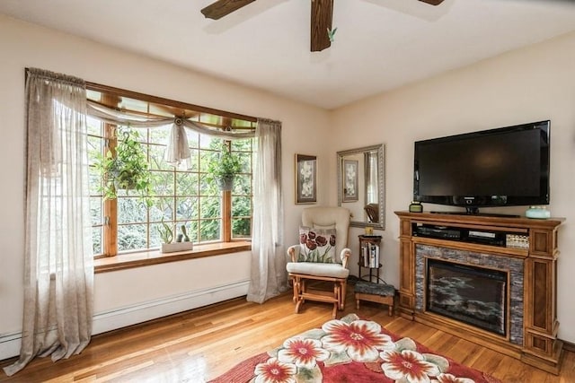2209 Post St, East Meadow, NY 11554 - living room with a ceiling fan, wood finished floors, baseboard heating, and a glass covered fireplace