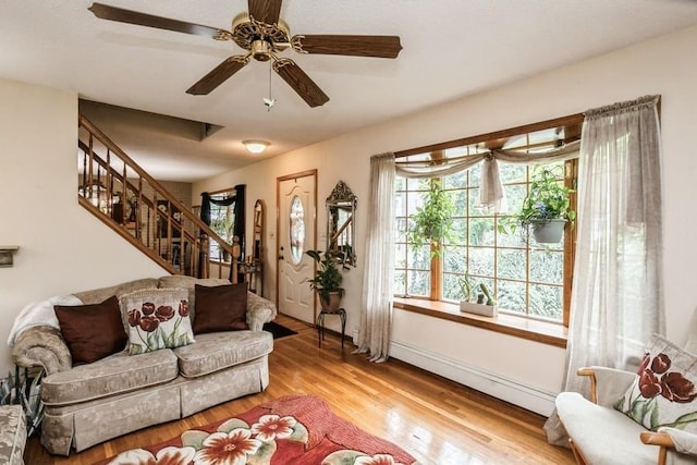 2209 Post St, East Meadow, NY 11554 - living room with a baseboard heating unit, healthy amount of natural light, light wood-type flooring, and stairway
