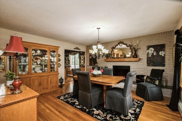 2209 Post St, East Meadow, NY 11554 - dining area with a chandelier, wood finished floors, a brick fireplace, and brick wall