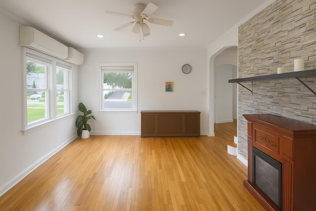26 Sherman Rd, Farmingdale, NY 11735 - unfurnished living room with a fireplace, light wood-type flooring, a ceiling fan, arched walkways, and ornamental molding