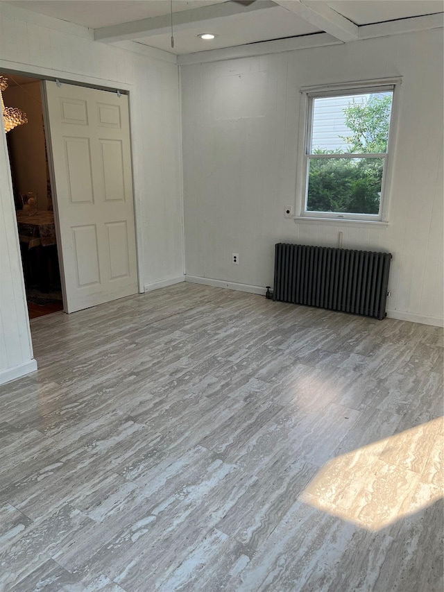 26 Sherman Rd, Farmingdale, NY 11735 - empty room featuring radiator, wood finished floors, beamed ceiling, and a chandelier