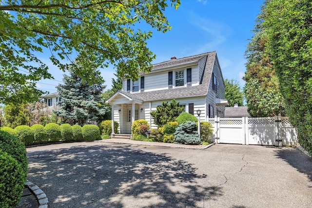 1277 Jerusalem Ave, Merrick, NY 11566 - view of front of property with a gate, a chimney, and roof with shingles