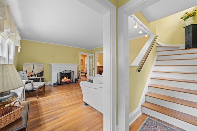 10 Wiltshire St, Bronxville, NY 10708 - stairway featuring wood finished floors, a brick fireplace, healthy amount of natural light, and rail lighting
