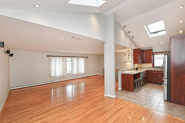36 Dawes Ave, Syosset, NY 11791 - kitchen with a skylight, open floor plan, light wood-type flooring, a baseboard heating unit, and stainless steel appliances