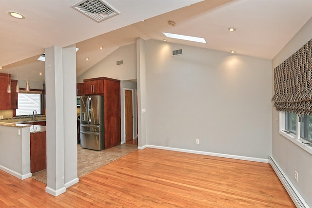 36 Dawes Ave, Syosset, NY 11791 - kitchen with stainless steel fridge, a baseboard radiator, light wood-style flooring, lofted ceiling, and a skylight