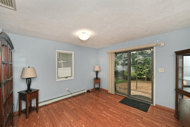 36 Dawes Ave, Syosset, NY 11791 - spare room featuring a baseboard radiator, wood finished floors, and a textured ceiling