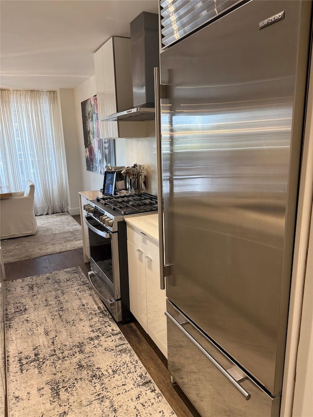 18-05 215th St Unit 2G, Bayside, NY 11360 - kitchen featuring appliances with stainless steel finishes, wall chimney exhaust hood, white cabinets, dark wood-style flooring, and modern cabinets