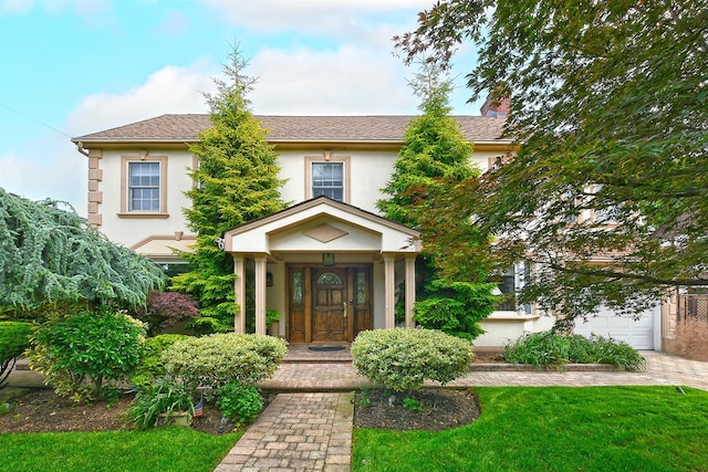3223 214th St, Bayside, NY 11361 - view of front of house with stucco siding, a chimney, a front lawn, a garage, and driveway