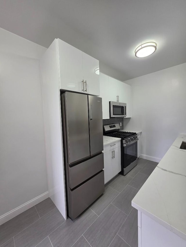 43-42 45th St Unit 4O, Sunnyside, NY 11104 - kitchen with appliances with stainless steel finishes, white cabinets, light countertops, and backsplash