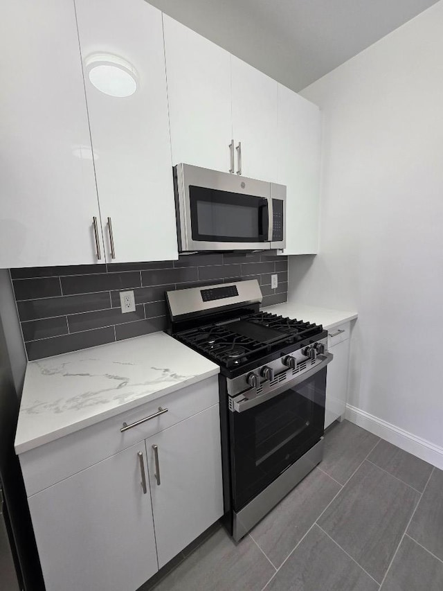 43-42 45th St Unit 4O, Sunnyside, NY 11104 - kitchen featuring appliances with stainless steel finishes, decorative backsplash, white cabinets, and light stone counters