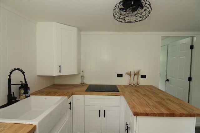 191 Sylvan Lake Rd Unit 1, Hopewell Junction, NY 12533 - kitchen featuring butcher block counters, black electric cooktop, a peninsula, and white cabinetry