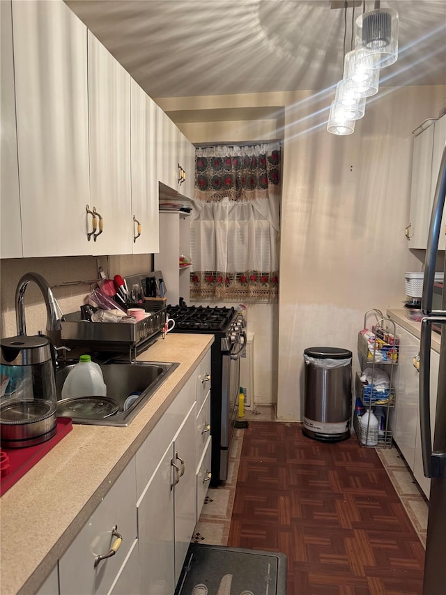 87-56 Francis Lewis Blvd Unit B31, Queens Village, NY 11427 - kitchen with gas range, light countertops, under cabinet range hood, white cabinets, and decorative light fixtures