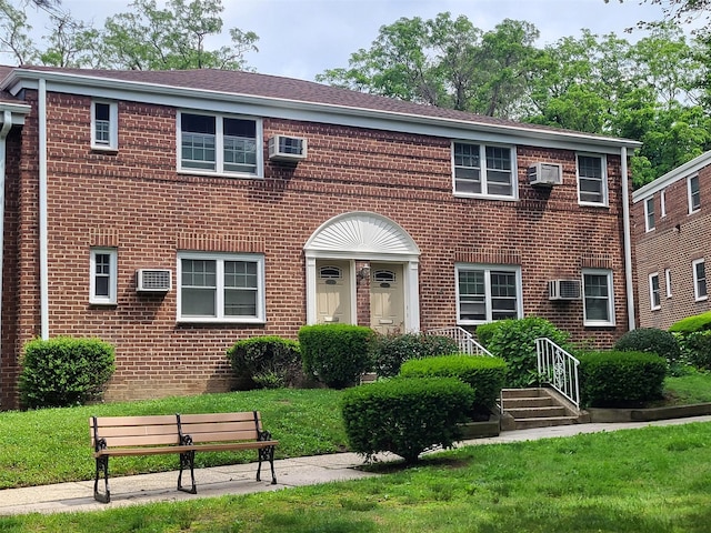 224-23 Kingsbury Ave Unit B, Oakland Gardens, NY 11364 - view of front of property featuring brick siding, a wall mounted air conditioner, a front yard, and a wall unit AC