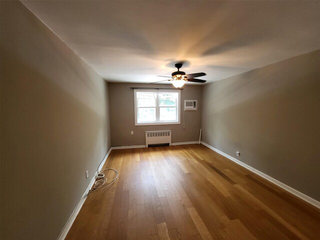 224-23 Kingsbury Ave Unit B, Oakland Gardens, NY 11364 - empty room featuring radiator heating unit, a wall mounted AC, ceiling fan, and wood finished floors