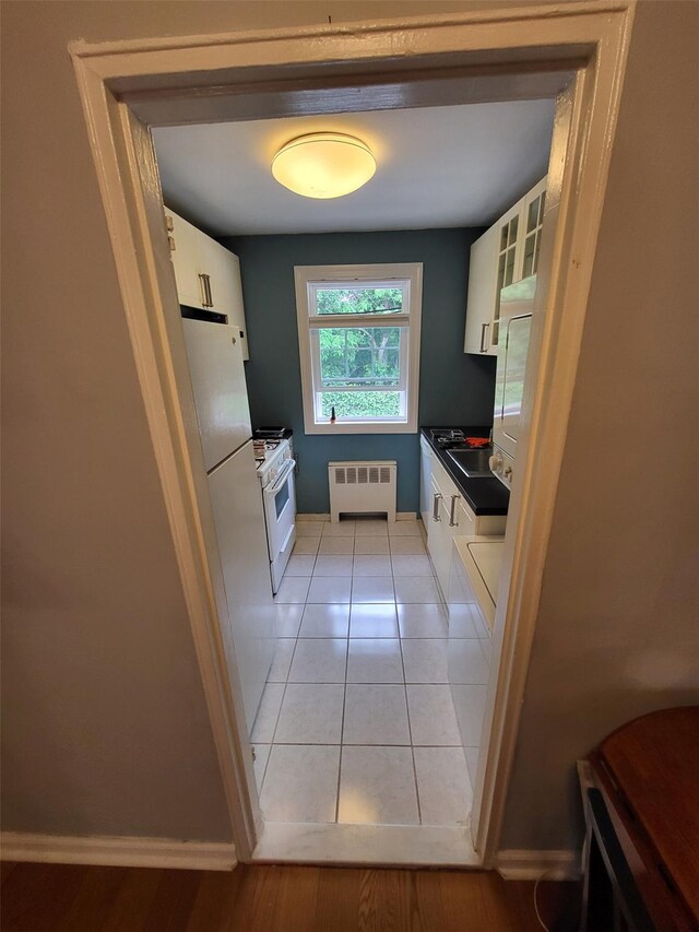 224-23 Kingsbury Ave Unit B, Oakland Gardens, NY 11364 - kitchen with radiator, dark countertops, white appliances, and white cabinetry