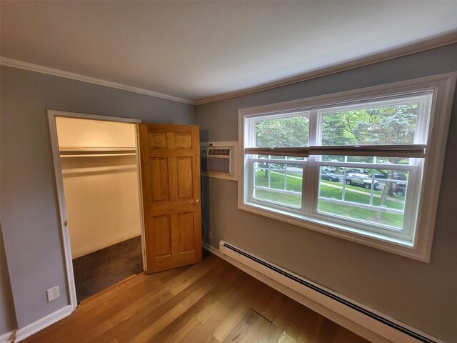 224-23 Kingsbury Ave Unit B, Oakland Gardens, NY 11364 - unfurnished bedroom with a baseboard radiator, light wood-style flooring, crown molding, a wall mounted AC, and a closet