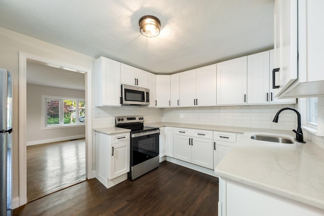 68 Henmond Blvd, Poughkeepsie, NY 12603 - kitchen with appliances with stainless steel finishes, dark wood-style flooring, tasteful backsplash, light stone countertops, and white cabinets