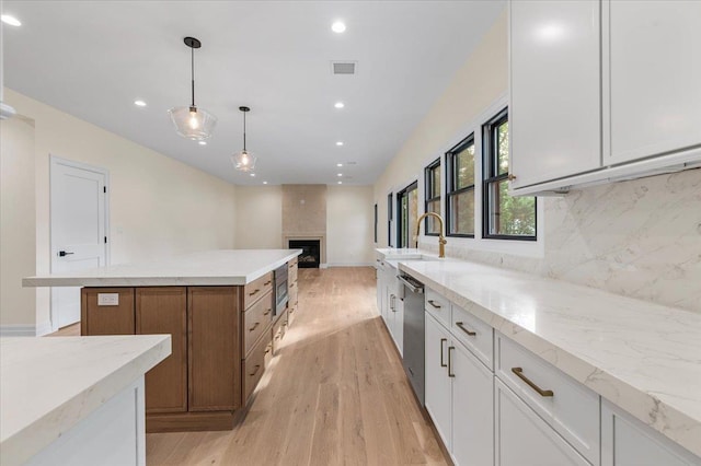 4 Haven Ln, Old Bethpage, NY 11804 - kitchen with appliances with stainless steel finishes, tasteful backsplash, light wood finished floors, a large fireplace, and a center island