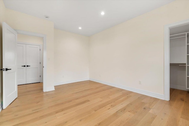 4 Haven Ln, Old Bethpage, NY 11804 - unfurnished bedroom featuring a walk in closet, light wood-style flooring, recessed lighting, and a closet
