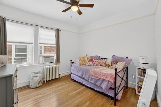 131 E 238th St, Bronx, NY 10470 - bedroom featuring radiator heating unit, light wood-type flooring, cooling unit, and ceiling fan