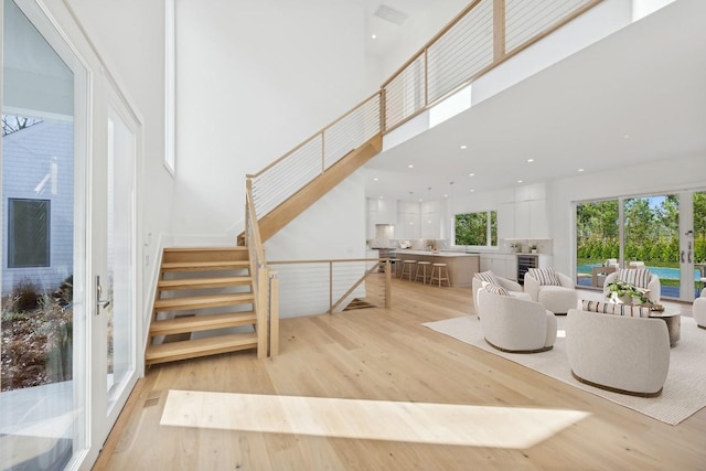 10 Broadwood Ct, Wainscott, NY 11975 - living room with a high ceiling, light wood-style flooring, stairway, recessed lighting, and french doors