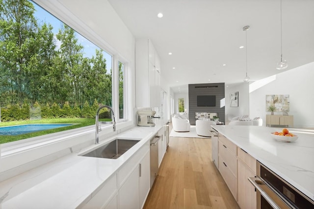 10 Broadwood Ct, Wainscott, NY 11975 - kitchen featuring modern cabinets, light wood-type flooring, recessed lighting, light stone counters, and open floor plan