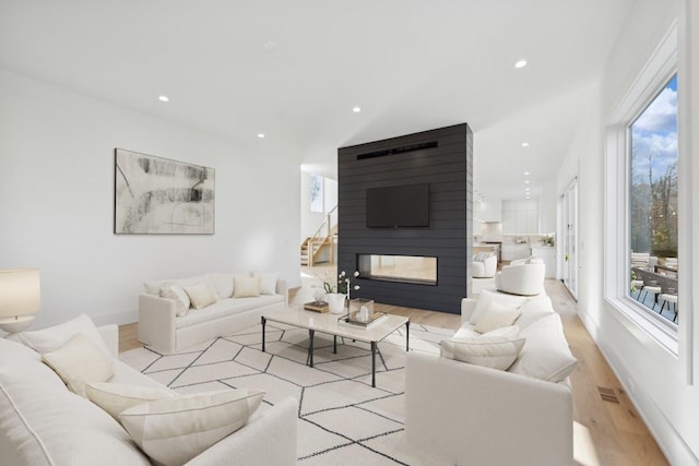 10 Broadwood Ct, Wainscott, NY 11975 - living room featuring wood finished floors, recessed lighting, stairs, and a large fireplace
