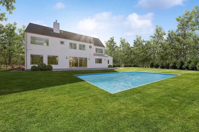 10 Broadwood Ct, Wainscott, NY 11975 - back of property featuring a chimney, a lawn, and an outdoor pool