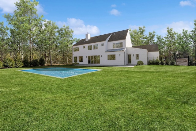 10 Broadwood Ct, Wainscott, NY 11975 - back of house featuring a chimney, an outdoor pool, and a lawn
