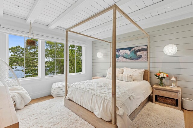 801 Montauk Hwy, Westhampton Beach, NY 11978 - bedroom featuring multiple windows, wood finished floors, wooden walls, and a wood ceiling with exposed beams
