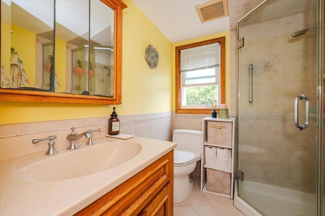 686 Barnes Ave, Baldwin, NY 11510 - bathroom with vanity, a stall shower, tile patterned floors, tile walls, and wainscoting