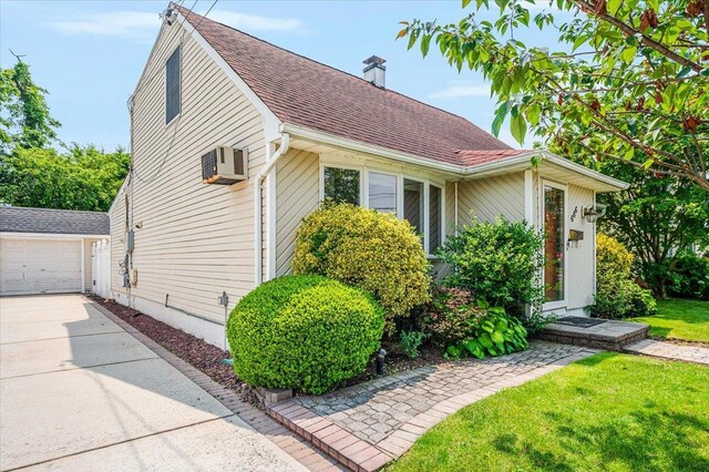 686 Barnes Ave, Baldwin, NY 11510 - view of front of home featuring an outbuilding, a chimney, concrete driveway, a front yard, and a shingled roof