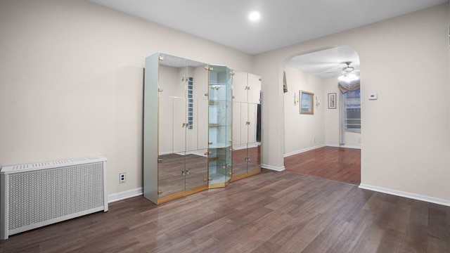 868 Morris Park Ave, Bronx, NY 10462 - spare room featuring radiator heating unit, arched walkways, wood finished floors, and a ceiling fan