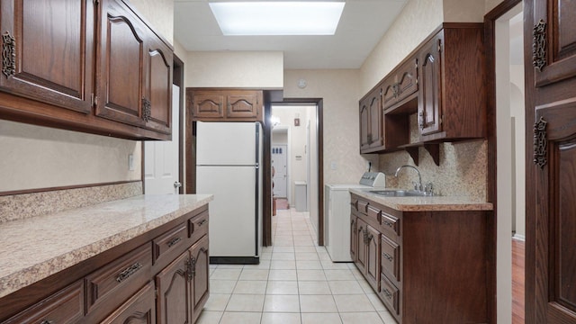 868 Morris Park Ave, Bronx, NY 10462 - kitchen featuring freestanding refrigerator, washing machine and dryer, light countertops, and dark brown cabinetry