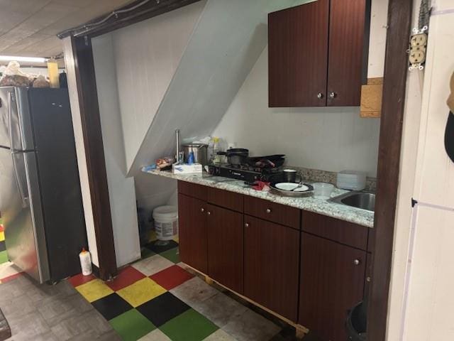 33-42 70th St, Jackson Heights, NY 11372 - kitchen featuring freestanding refrigerator, light flooring, light countertops, and dark brown cabinetry