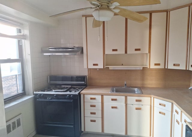 2866 Marion Ave Unit 4C, Bronx, NY 10458 - kitchen featuring gas range, under cabinet range hood, decorative backsplash, radiator heating unit, and plenty of natural light
