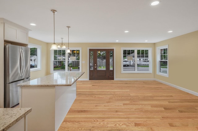 159 Mohawk St, Ronkonkoma, NY 11779 - kitchen with freestanding refrigerator, recessed lighting, white cabinets, pendant lighting, and light stone counters