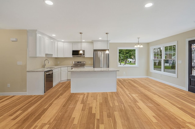 159 Mohawk St, Ronkonkoma, NY 11779 - kitchen featuring stainless steel appliances, a kitchen island, light wood-style flooring, white cabinets, and recessed lighting
