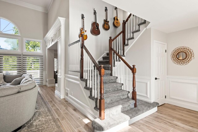 62 Hamlet Dr, Commack, NY 11725 - stairs with wood finished floors, wainscoting, a decorative wall, and ornamental molding