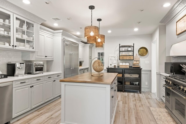 62 Hamlet Dr, Commack, NY 11725 - kitchen featuring premium appliances, a kitchen island, tasteful backsplash, butcher block countertops, and light wood-style flooring