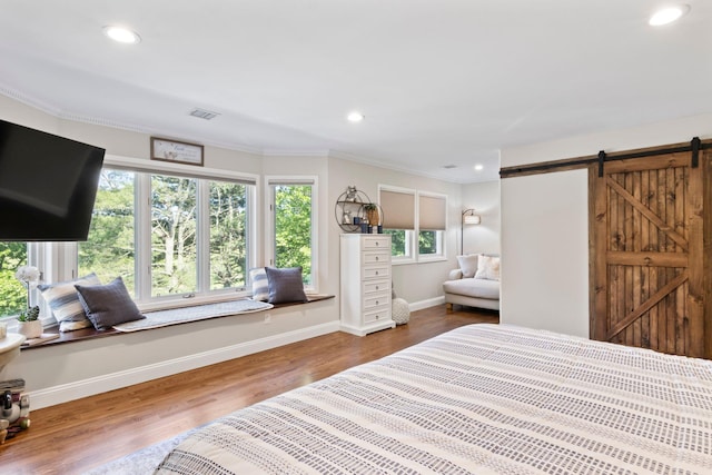 62 Hamlet Dr, Commack, NY 11725 - bedroom featuring a barn door, recessed lighting, ornamental molding, and wood finished floors