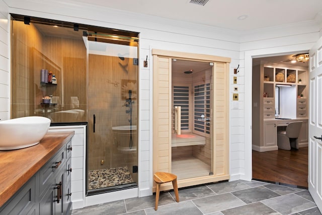 62 Hamlet Dr, Commack, NY 11725 - bathroom featuring vanity, a stall shower, ornamental molding, and wood walls
