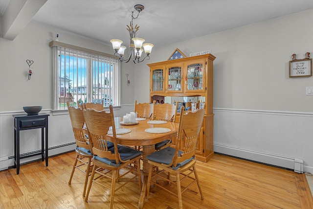 115 W Granada Ave, Lindenhurst, NY 11757 - dining room with a baseboard heating unit, a chandelier, a wainscoted wall, light wood-style flooring, and a baseboard radiator