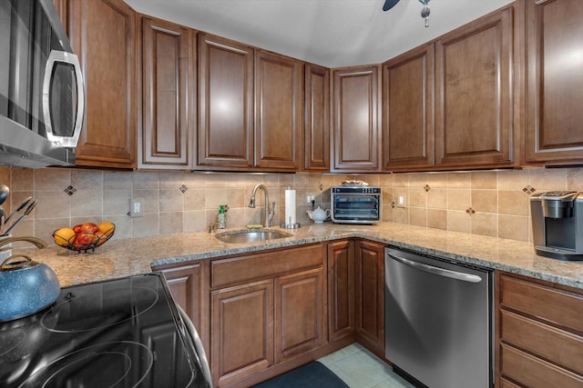 115 W Granada Ave, Lindenhurst, NY 11757 - kitchen featuring stainless steel appliances, light stone countertops, decorative backsplash, and brown cabinetry