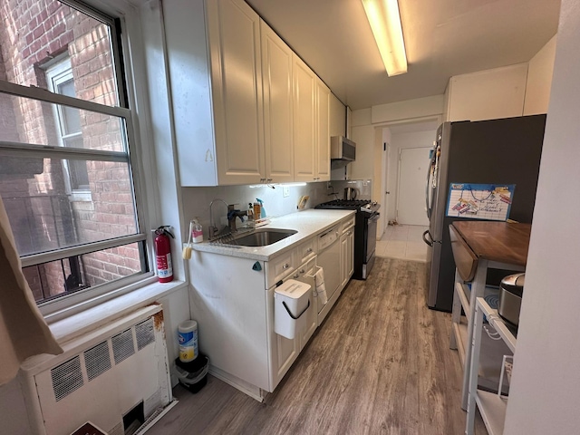 209-15 18th Ave Unit 2A, Bayside, NY 11360 - kitchen featuring gas range, radiator heating unit, freestanding refrigerator, light wood-type flooring, and extractor fan