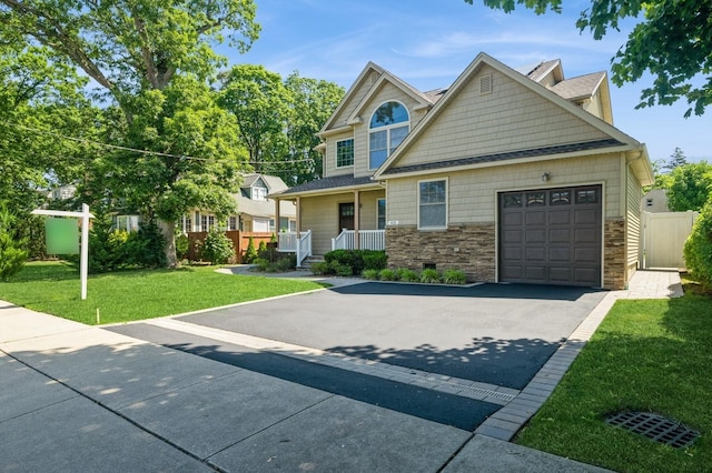 413 Robyn Pl, East Meadow, NY 11554 - view of front of house with driveway, stone siding, an attached garage, and a porch