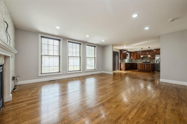 413 Robyn Pl, East Meadow, NY 11554 - unfurnished living room with recessed lighting, a large fireplace, and dark wood-style floors