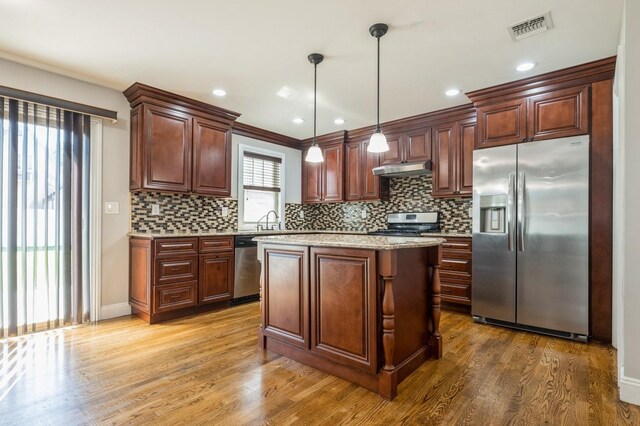 413 Robyn Pl, East Meadow, NY 11554 - kitchen with stainless steel appliances, wood finished floors, backsplash, and recessed lighting