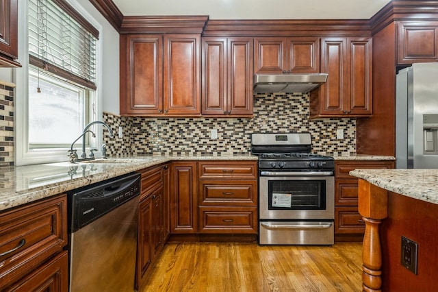413 Robyn Pl, East Meadow, NY 11554 - kitchen featuring stainless steel appliances, under cabinet range hood, light wood-style floors, tasteful backsplash, and light stone countertops